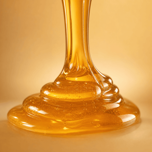 Golden honey texture flowing smoothly to represent hydration and moisture retention for soft skin