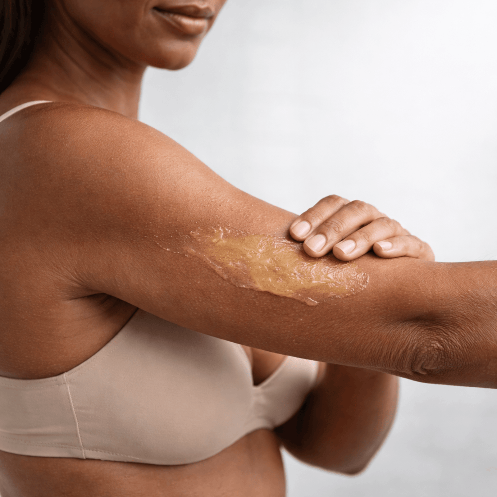 Close up of applying anti cellulite cream on arm with smooth even coverage