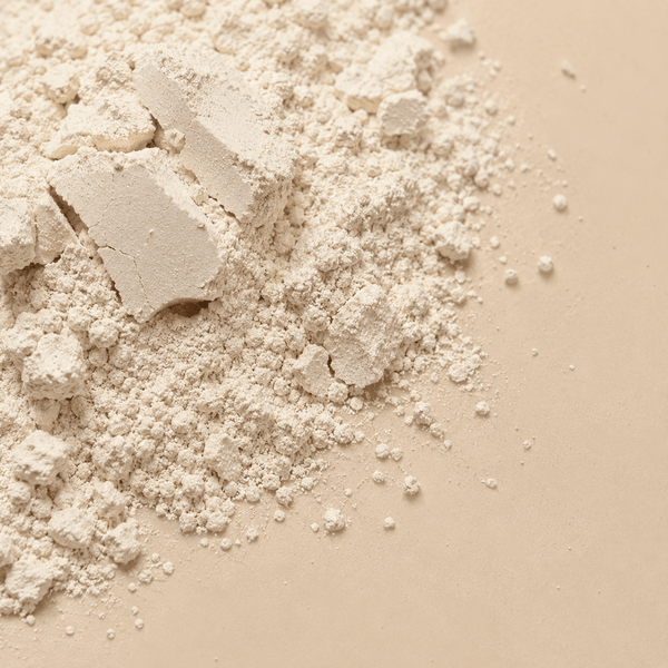 Natural white kaolin clay powder on a beige surface for shine control skincare ingredient by Olivine Beauty