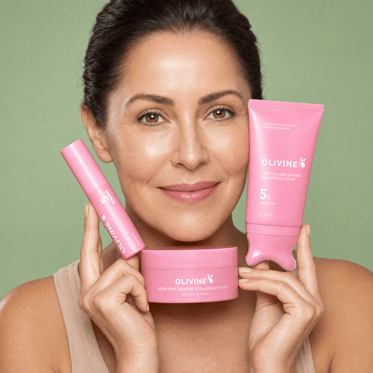 Woman holding the Olivine PDRN pink skincare line — Pink Stick, collagen eye patch and Gua Sha neck cream