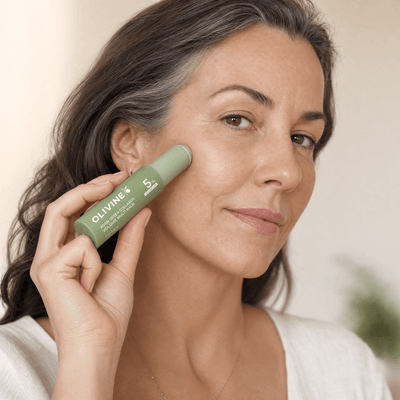 Woman applying the Olivine Beauty PDRN Green Collagen Volume Multi Balm stick to her cheek