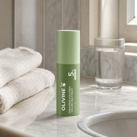 Olivine Beauty PDRN Green Collagen Volume Multi Balm stick on a marble bathroom vanity