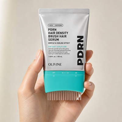 Woman holding the PDRN Hair Density Brush Serum tube