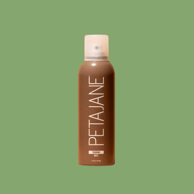 A single bottle of Olivine Beauty Tanning Mist centered on a solid sage green background, highlighting the minimalist packaging.
